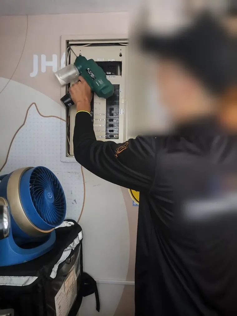 技師在電箱內部施打驅鼠粉