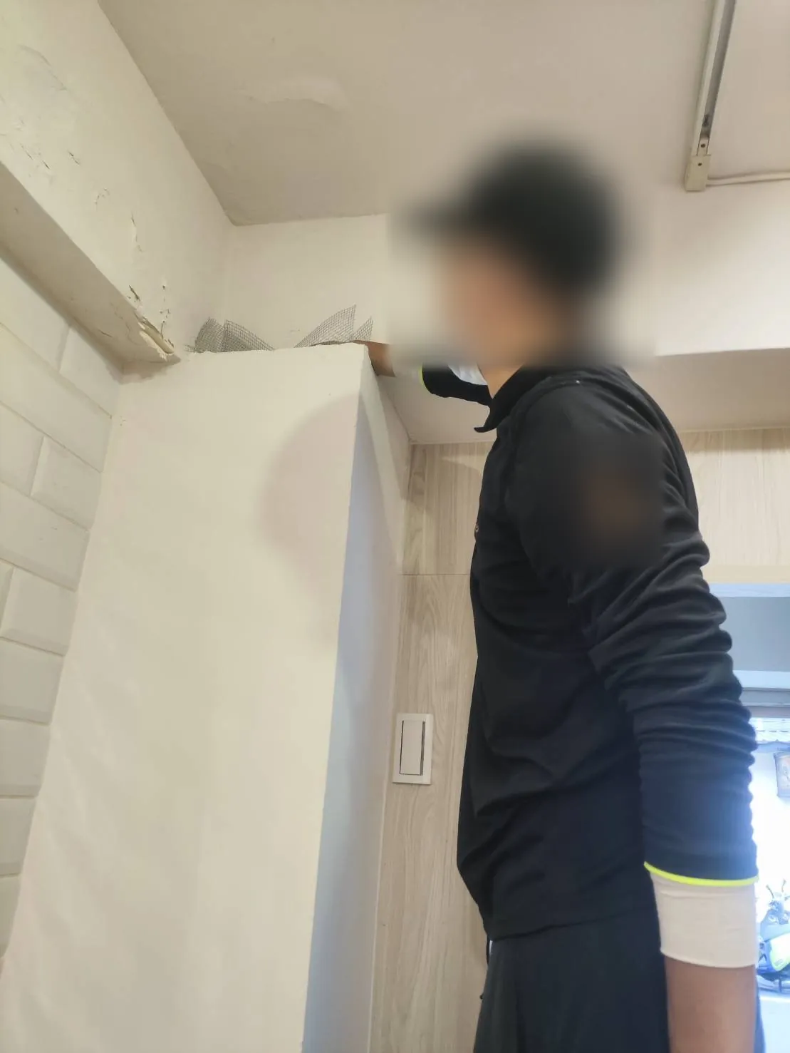 技師檢查天花板與櫃體上方交界的孔隙