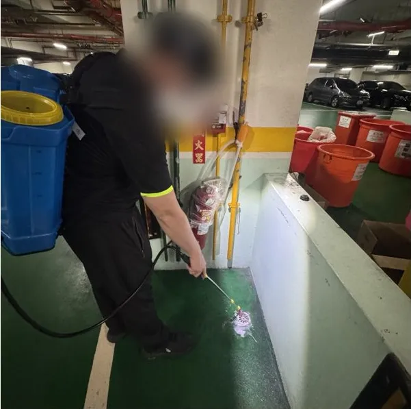 技師對地面排水孔灌藥（臉部已模糊）