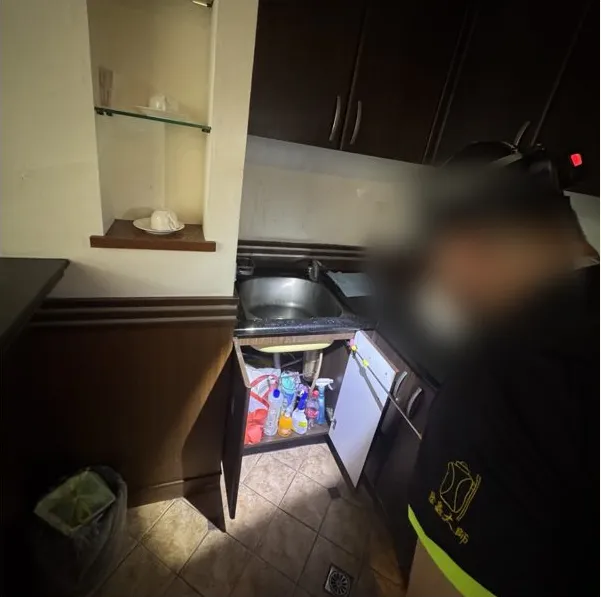 打開管理室茶水櫃門，處理櫃內隱蔽位置（臉部已模糊）