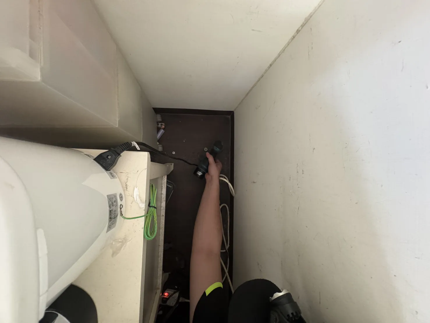 冷氣下方與牆之間的窄縫，技師處理靠地板的位置
