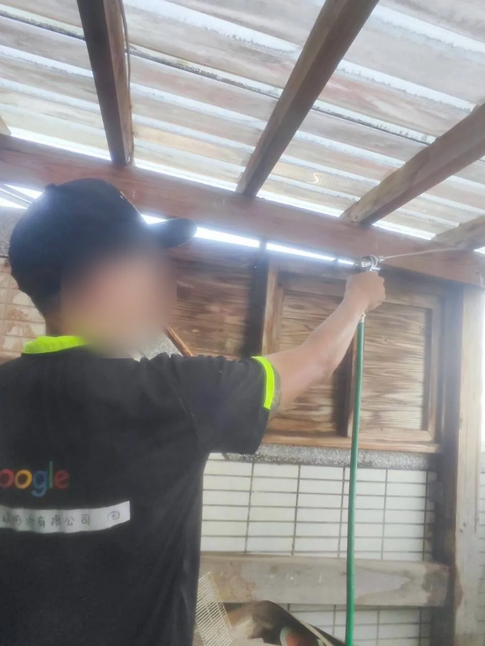 技師對戶外木造屋簷施作（臉部已模糊）