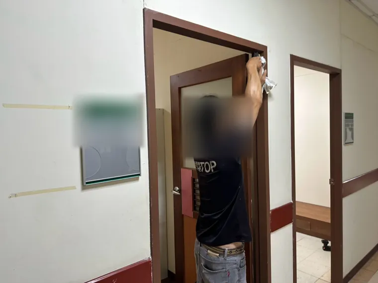 技師處理研究室門框（臉部與門牌已模糊）