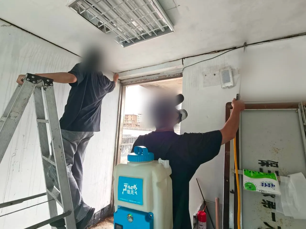 兩位技師分工處理窗框上緣與下緣