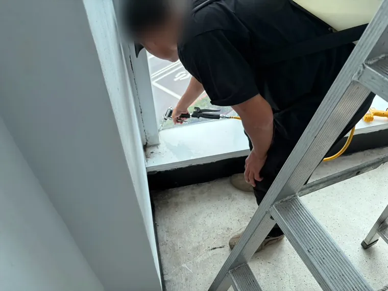 技師蹲低對低處窗台噴灑