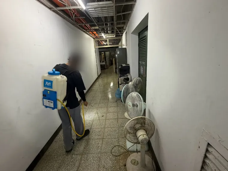 長走廊兩側牆腳以電動噴霧器噴灑