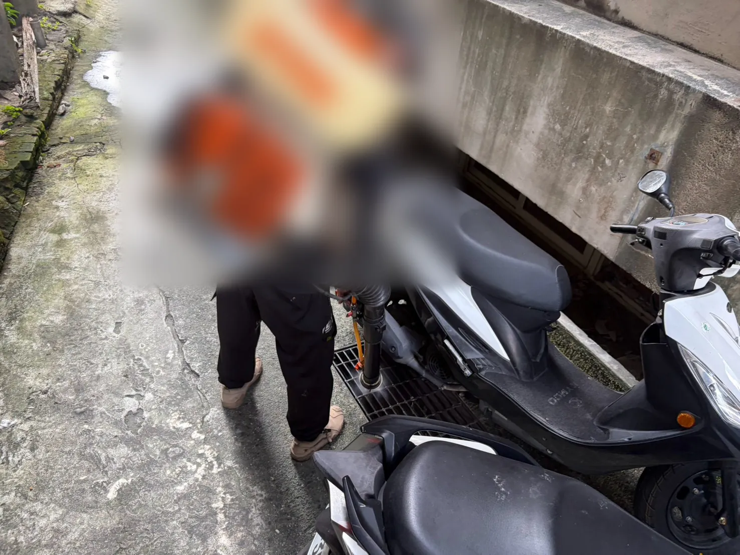 機車旁水溝以噴頭伸入施作