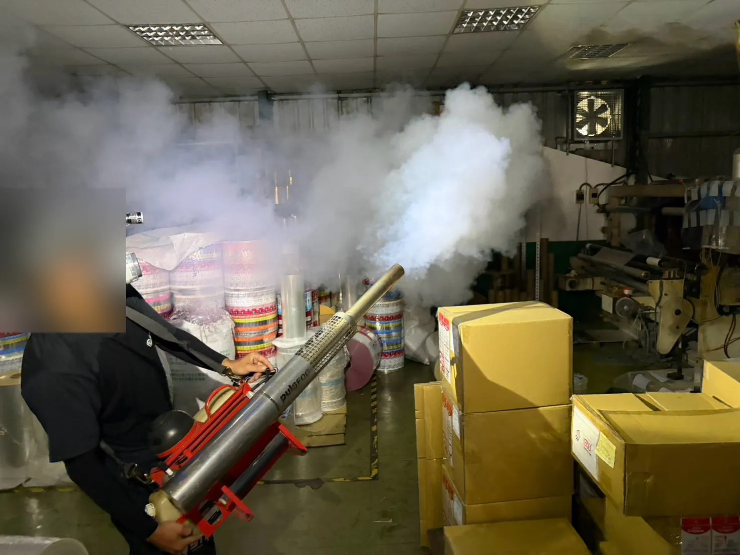 業者在塑膠工廠包裝區用熱煙霧機消毒