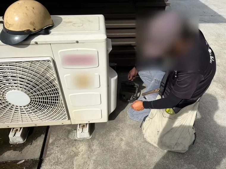 技師在冷氣室外機旁檢查鼠餌盒