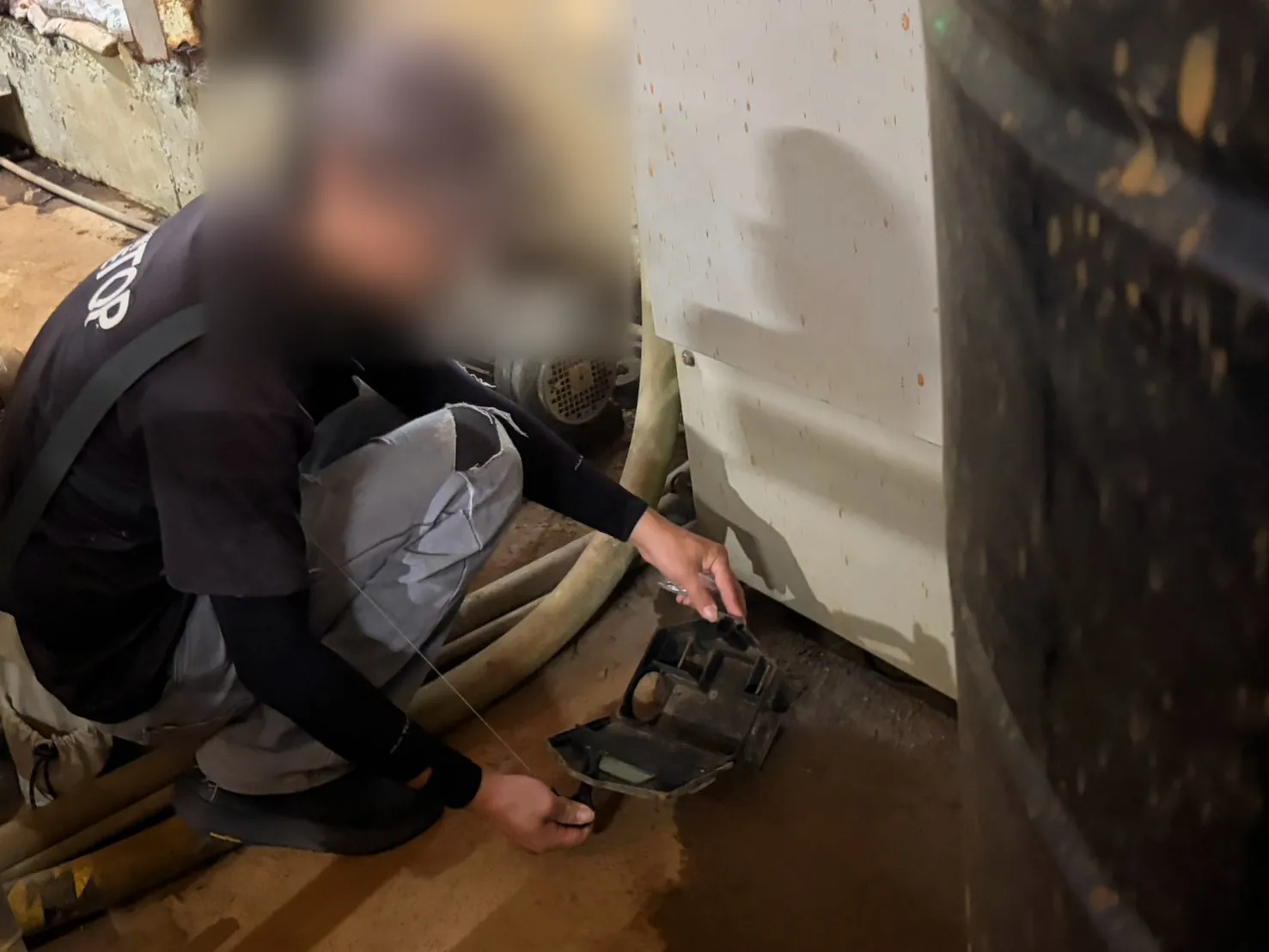 技師在機房馬達設備旁打開鼠餌盒