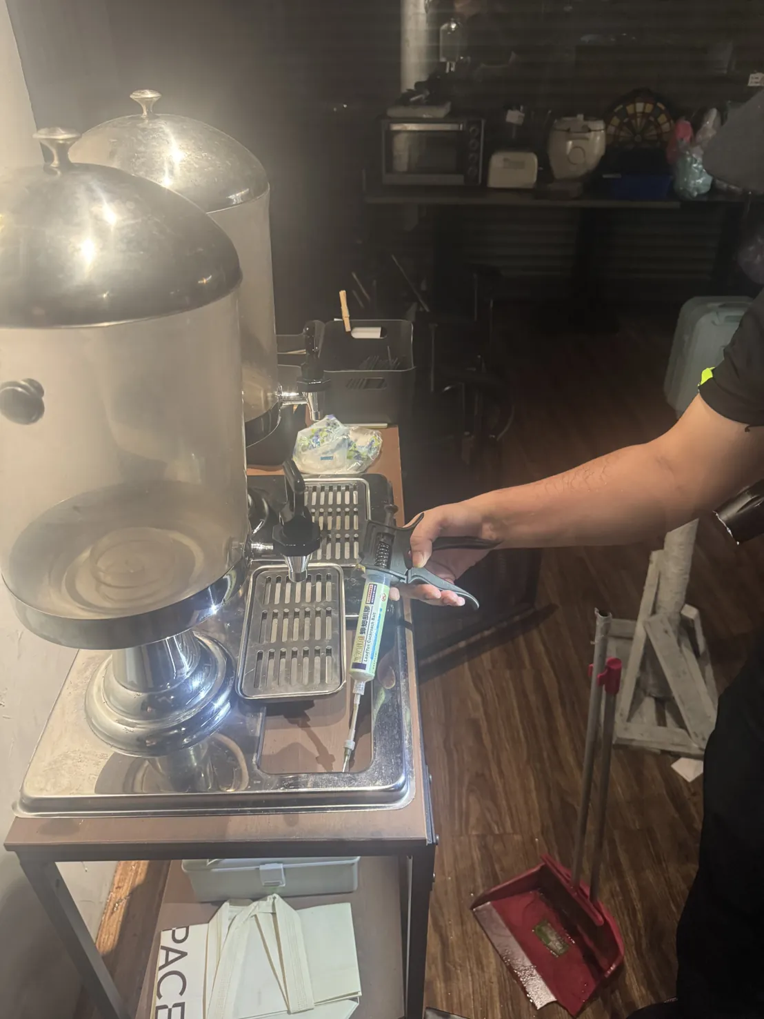 技師在飲料機旁的層架縫隙點上膠餌