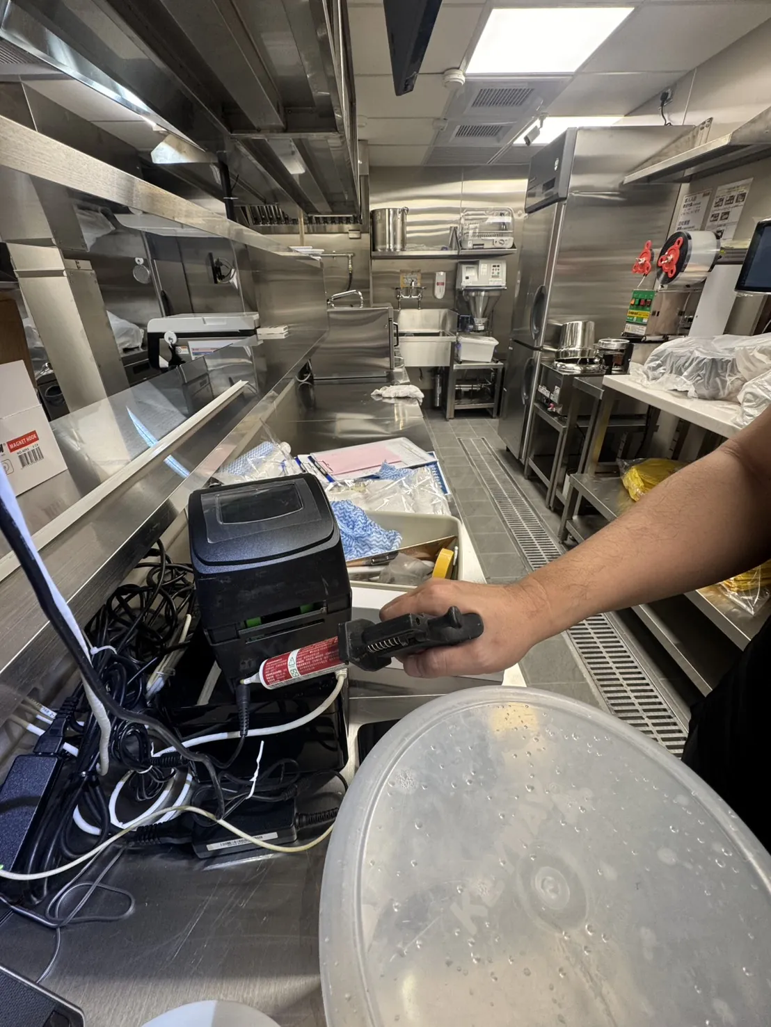 業者在電子設備後方線路周邊點餌膠