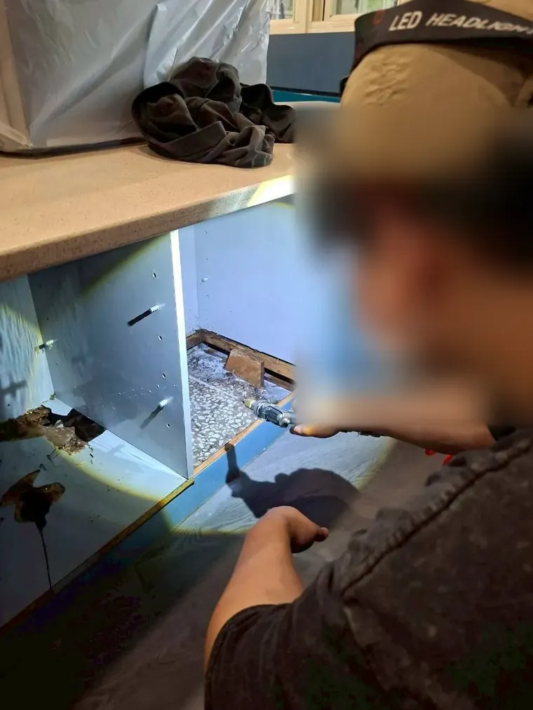 技師在系統櫃內部鑽孔準備注藥