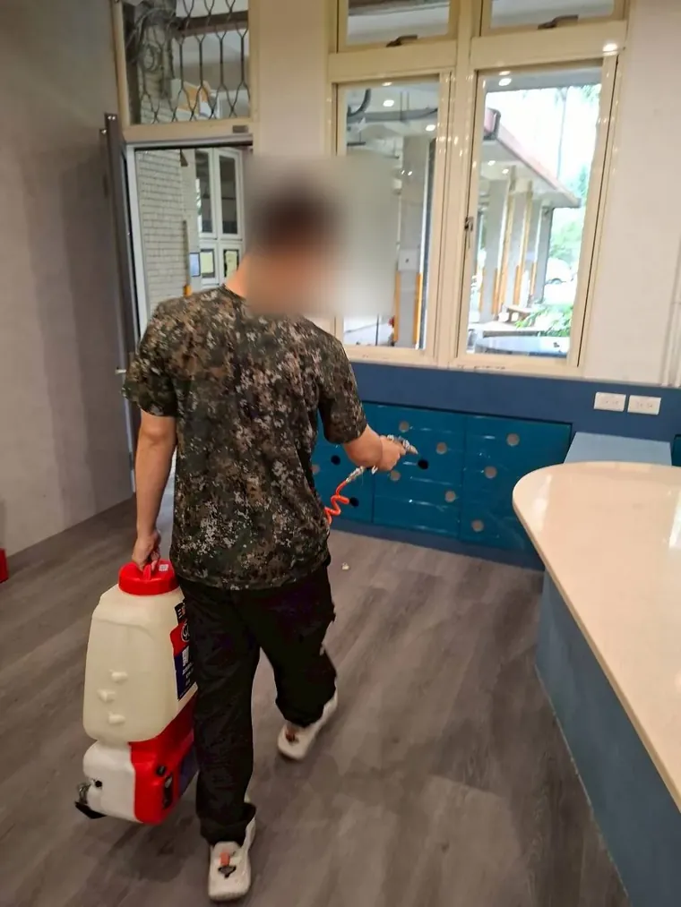 技師背加壓藥桶沿教室地板邊緣施藥