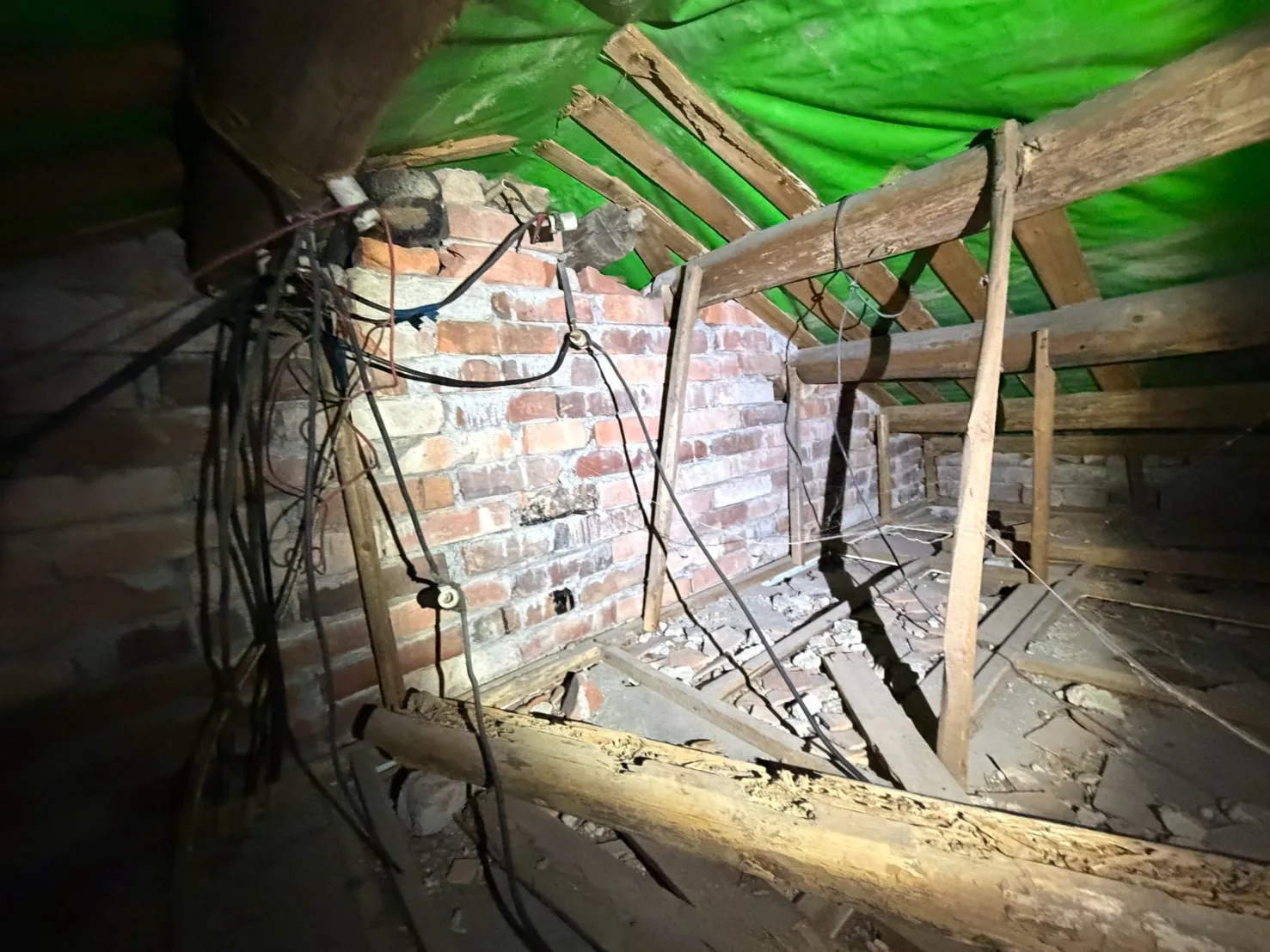 屋頂夾層內的紅磚牆與多條老舊電線