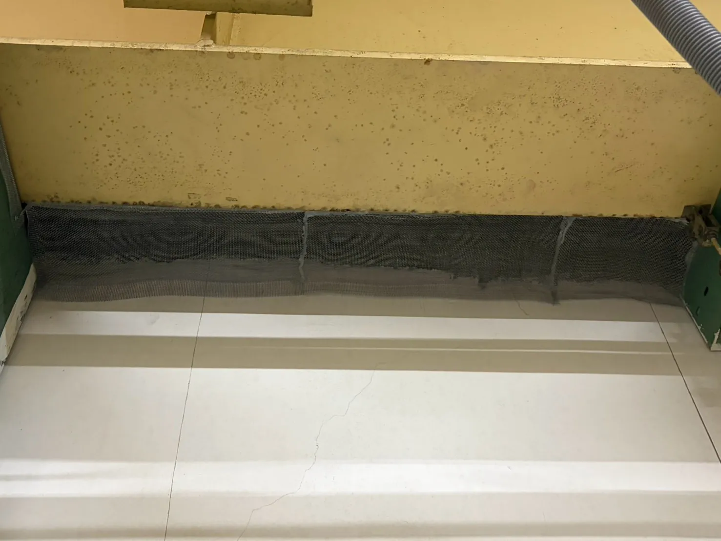 整面牆頂的長縫以金屬網一段接一段連續封住