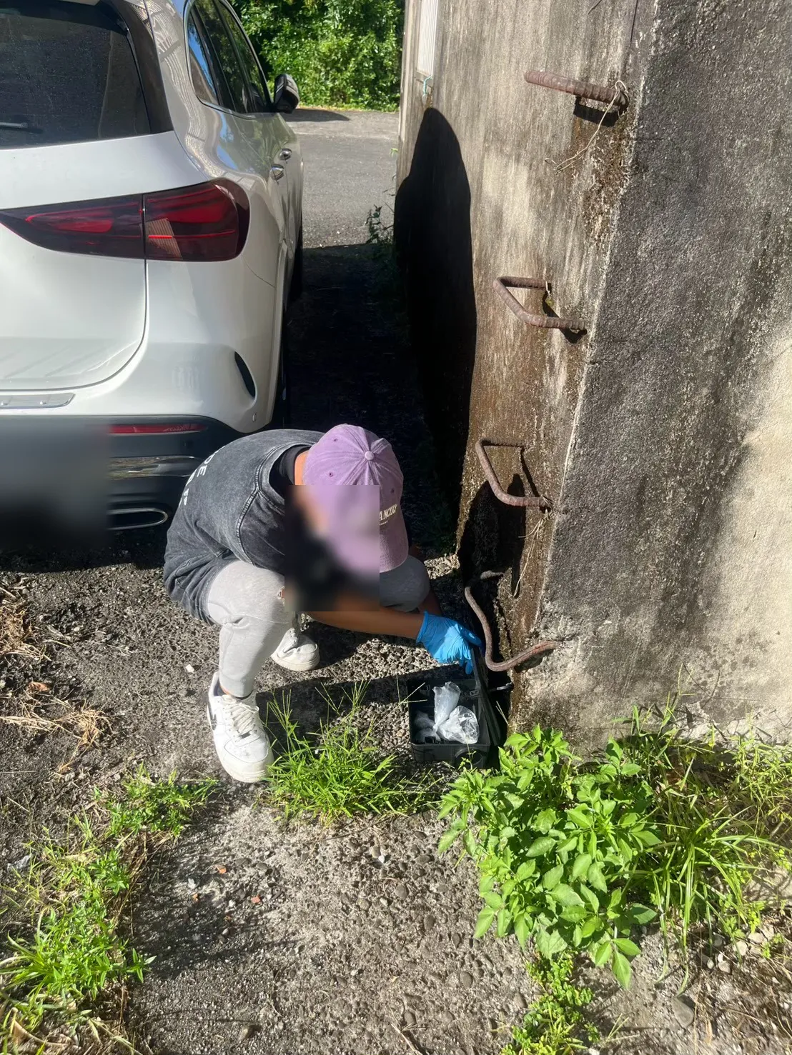 業者在工廠車道邊停車處牆腳放置鼠餌盒