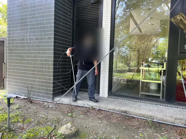 技師沿建物外牆牆腳與土面交接處噴灑