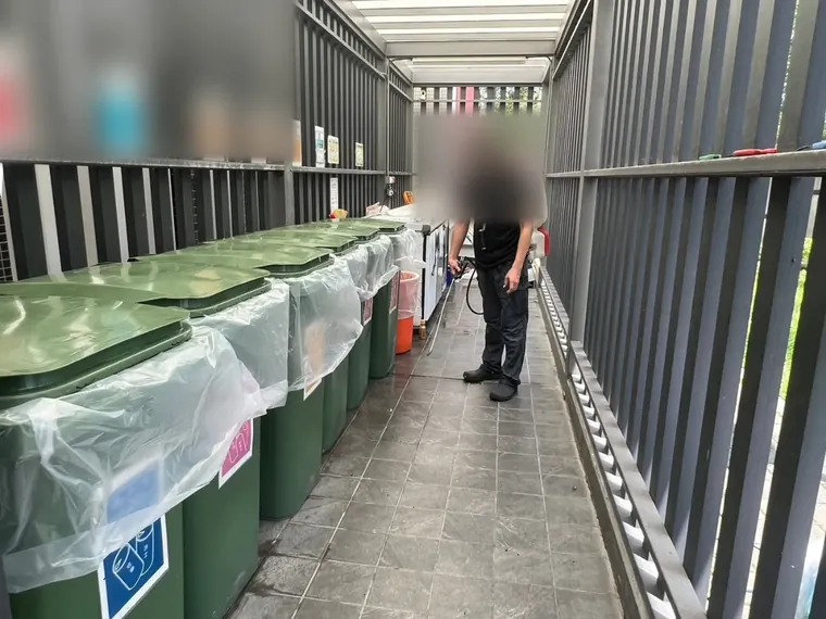 社區垃圾分類區整排垃圾桶旁噴灑