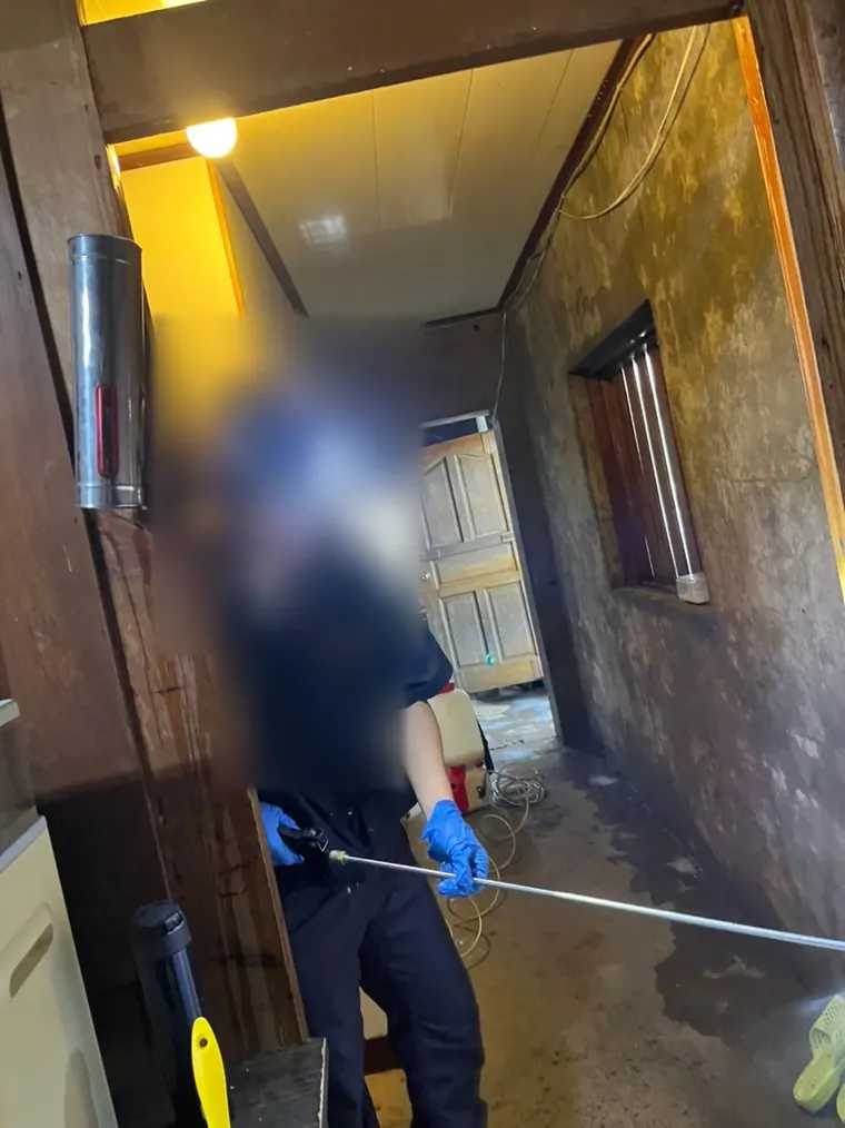 技師以加長噴桿在老屋走廊施藥